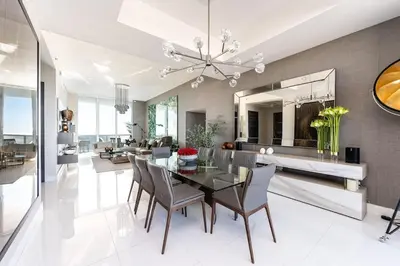 a dining room with a glass table and chairs at Sophisticated Modern Gem with Unreal Ocean Views in Sunny Isles Beach