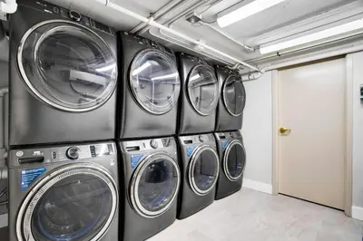 a row of four washing machines in a laundry room at Vonder Miami Beach - Unit 4 in Miami Beach