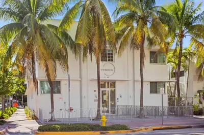 a white building with palm trees in front of it at Vonder Miami Beach - Unit 6 in Miami Beach