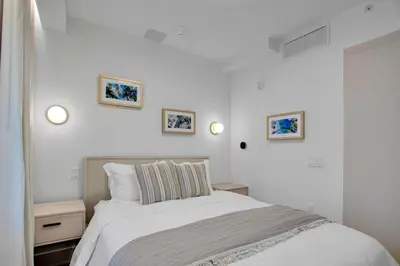 a white bedroom with a bed and three pictures on the wall at Vonder Miami Beach - Unit 8 in Miami Beach