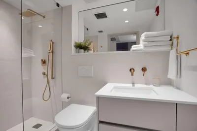 a white bathroom with a toilet and a sink at Vonder Miami Beach - Unit 8 in Miami Beach