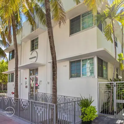 a white building with palm trees in front of it at Vonder Miami Beach - Unit 19 in Miami Beach