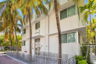 a white building with palm trees in front of it at Vonder Miami Beach - Unit 20 in Miami Beach