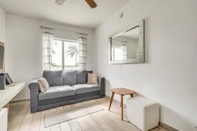a living room with a couch and a mirror at Cozy Miami Beach Apartment Less Than 1 Mi to Ocean! in Miami Beach