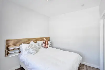 a bed with white sheets and pillows in a room at Miami Beach Home, 7 guests, Steps from the beach in Miami Beach