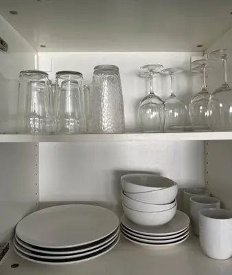 a shelf with plates and glass jars and bowls at Walk to the beach, Studio, Pool AND FREE Parking in Hallandale Beach
