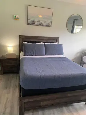 a bedroom with a bed with blue sheets and a mirror at Walk to the beach, Studio, Pool AND FREE Parking in Hallandale Beach