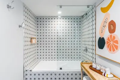 a bathroom with a tub and a tiled wall at The Palms Coconut Grove 1 bedroom condo includes parking in Miami