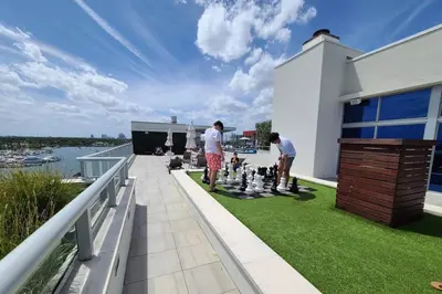 two men playing chess on the balcony of a house at Luxury Beach Front Suite with Rooftop Pool in Hollywood