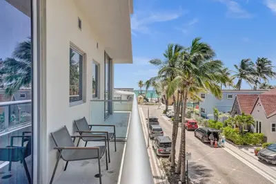 a balcony with chairs and a view of a street at Luxury Beach Front Suite with Rooftop Pool in Hollywood