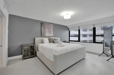 a white bedroom with a large bed and windows at Ocean View Elegant 2BDR 2BA Condo Beach Access 714 in Miami Beach