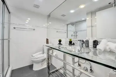 a white bathroom with a sink and a toilet at Cozy Ocean View Condo Beach Service 617 in Miami Beach