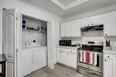 a kitchen with white cabinets and a stove top oven at Beautiful Home in Maimi in Miami