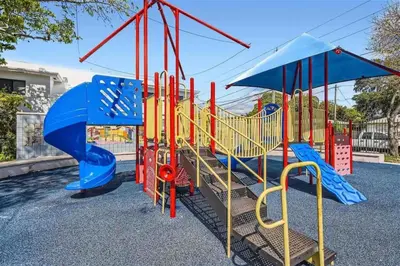 a playground with a blue and red slide at Beautiful Home in Maimi in Miami