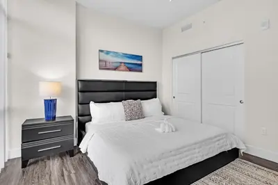 a bedroom with a large bed with a black headboard at Bright and Airy 2 Bed on Biscayne Blvd with Free Park in Miami