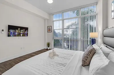a bedroom with a large white bed with a teddy bear on it at Bright and Airy 2 Bed on Biscayne Blvd with Free Park in Miami