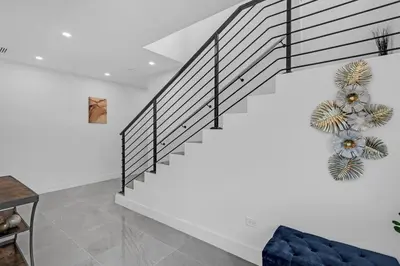 a staircase in a living room with a blue couch at Paraiso House Pool 10 Ppl 6 mins Coconut Grove in Miami