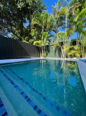 a swimming pool with blue water and palm trees at Paraiso House Pool 10 Ppl 6 mins Coconut Grove in Miami