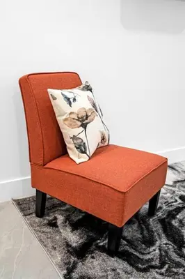 a red chair with a pillow on top of a rug at Paraiso House Pool 10 Ppl 6 mins Coconut Grove in Miami