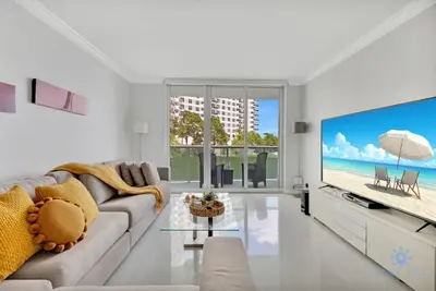 a living room with a couch and a large screen tv at Beautiful apartment with pool and gym in Hollywood