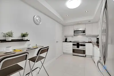 a white kitchen with a counter and chairs in it at Beautiful apartment with pool and gym in Hollywood