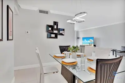 a dining room with a glass table and chairs at Beautiful apartment with pool and gym in Hollywood
