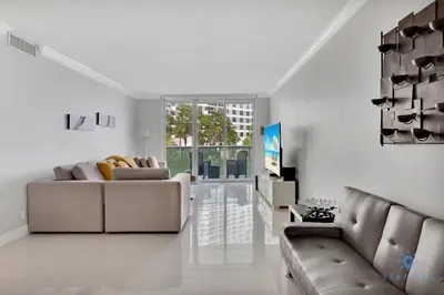 a living room with a couch and a tv at Beautiful apartment with pool and gym in Hollywood