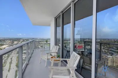 a balcony with chairs and a table on a building at High Floor 3BR - 2BA - Resort Fees & Parking Incl in Hollywood