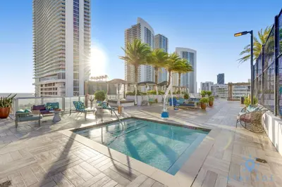 an apartment patio with a swimming pool and palm trees at High Floor 3BR - 2BA - Resort Fees & Parking Incl in Hollywood