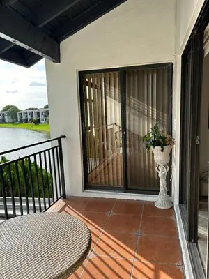 a balcony with a table and a vase with a plant at Beautiful apartment with very elegant colonial decoration in Tamiami