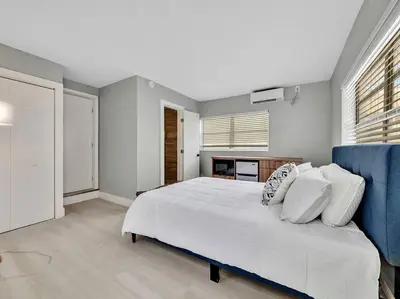 a bedroom with a white bed and a blue couch at Coastal Escape, Hollywood Beach Proximity in Hollywood