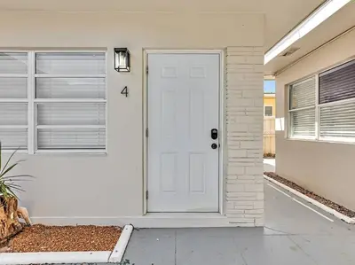 a white door on a white house with windows at Coastal Escape, Hollywood Beach Proximity in Hollywood