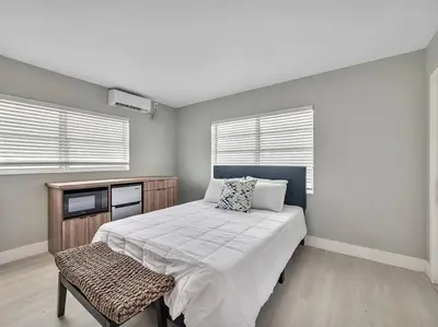 a bedroom with a large bed and two windows at Coastal Escape, Hollywood Beach Proximity in Hollywood