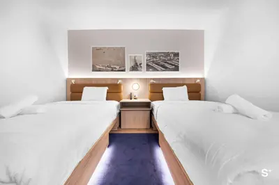 two beds in a small room with white walls at Modern 1BD & Den With City Views in Miami