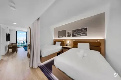 a hotel room with two beds and a balcony at Modern 1BD & Den With City Views in Miami