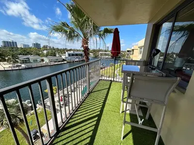 a balcony with a table and a view of the water at Beautiful Water View Golden Isles in Hallandale Beach