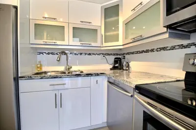 a white kitchen with white cabinets and a sink at Golden Isles # 509 in Hallandale Beach