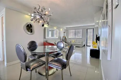 a dining room and living room with a glass table and chairs at Golden Isles # 509 in Hallandale Beach