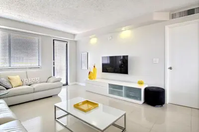 a living room with a couch and a tv on a wall at Golden Isles # 509 in Hallandale Beach