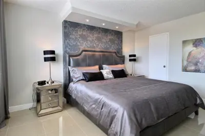 a bedroom with a large bed and two lamps at Golden Isles # 509 in Hallandale Beach