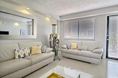 a living room with two couches and a table at Golden Isles # 509 in Hallandale Beach