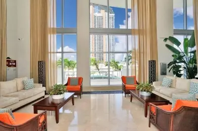 a living room with couches and chairs and large windows at Amazing Apartment Oceanview Beautiful Amenities in Sunny Isles Beach