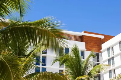 a white building with palm trees in front of it at The Gates Hotel South Beach in Miami Beach