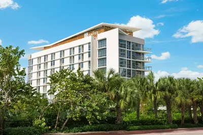 a white building with palm trees in front of it at The Gates Hotel South Beach in Miami Beach
