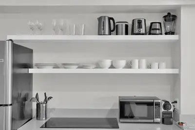 a kitchen with shelves with cups and a microwave at 2bedroom City Ocean Treasure in Miami