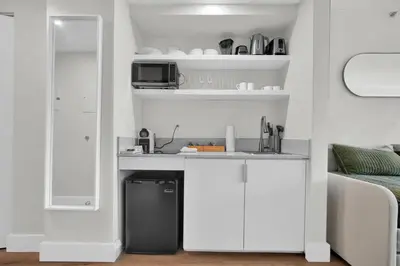 a kitchen with white cabinets and a microwave at Find Tranquility in the Grove in Miami