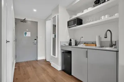 a white kitchen with a sink and a counter at Find Tranquility in the Grove in Miami