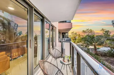 a balcony with two chairs and a view of the ocean at Beautiful 2 Br Apartment Amazing Pool in Miami Beach
