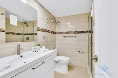 a white bathroom with a toilet and a shower at Beautiful 2 Br Apartment Amazing Pool in Miami Beach