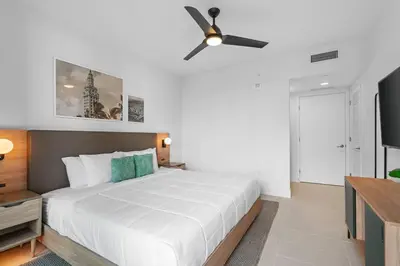 a bedroom with a white bed and a ceiling fan at New Luxury Apartment at Downtown Miami in Miami